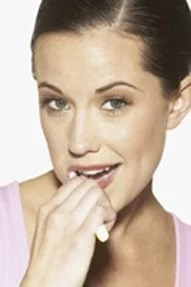 Woman biting her nails, illustrating habits that can lead to chipped teeth or jaw issues