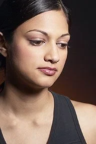 A woman looking concerned, representing dental anxiety or the need for emergency dental care