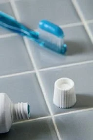 Dental hygiene tools on a bathroom tile, emphasizing daily plaque removal at home
